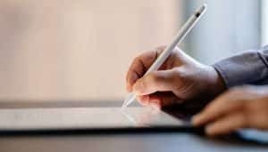 person writing with stylus on ipad