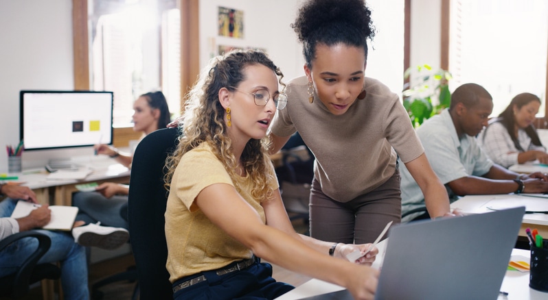 Shot of two young businesswomen using a laptop together in a modern office